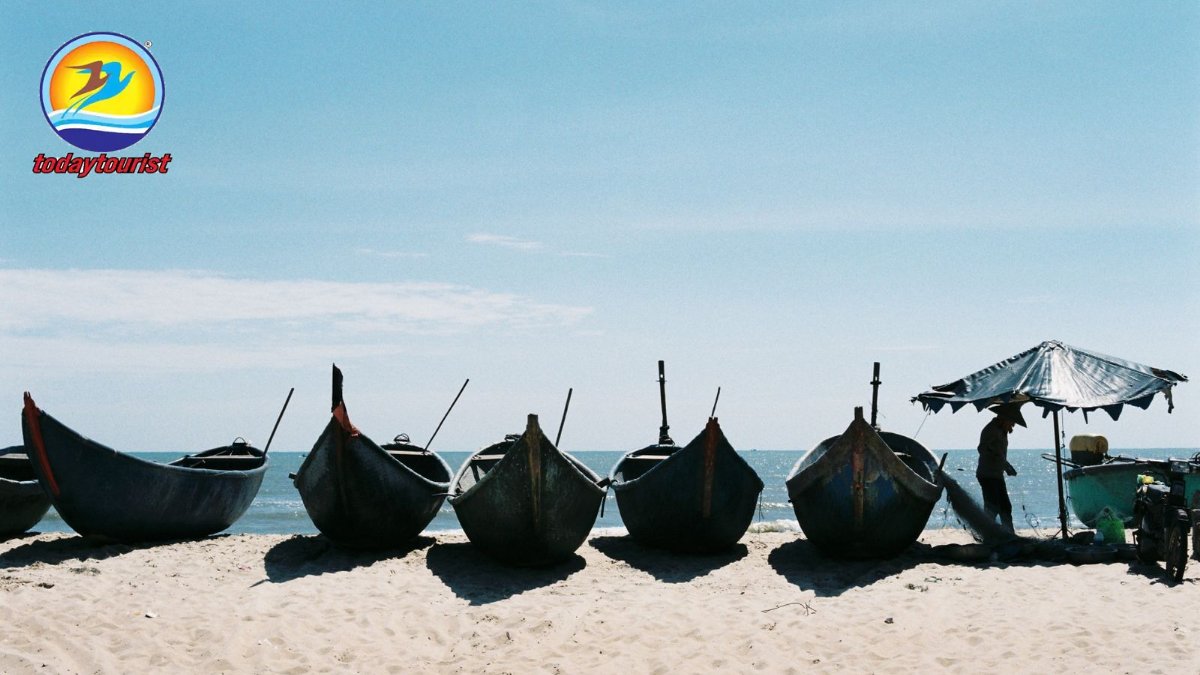 Fishing boats lined up on a serene beach in Ba Ria, Vietnam under a cl