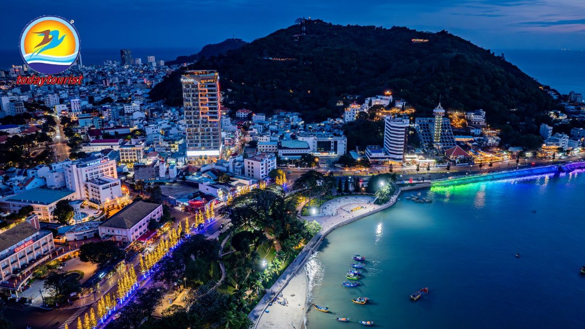 Stunning aerial view of a lively coastal city at night, illuminated by