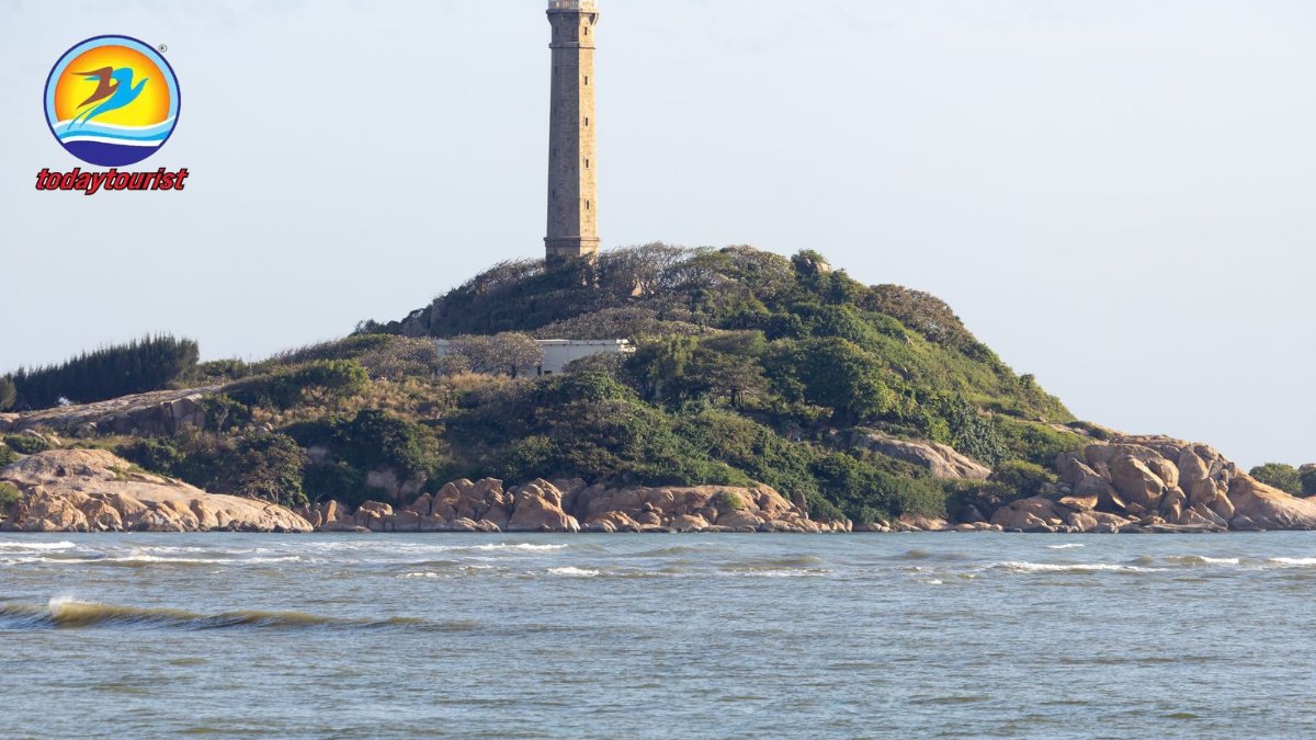 A lighthouse stands tall on a lush, rocky island surrounded by the ser